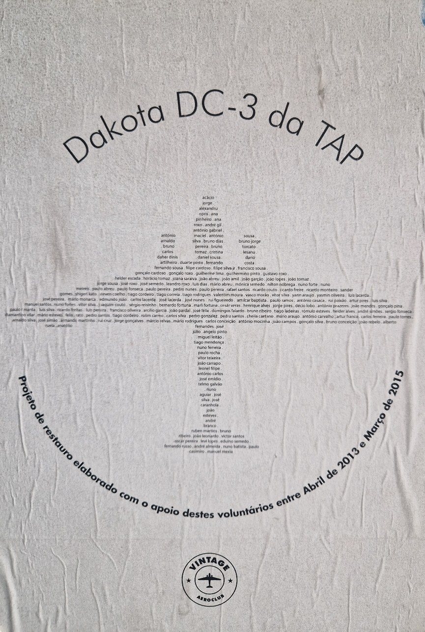 Poster original afixado no Dakota CS-TDE, com o nome de cada voluntário da restauração, desenhando a silhueta do avião
